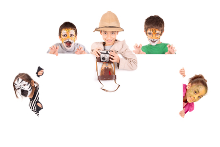 Children's group in safari clothes and animal face-paint over a white boardの写真素材