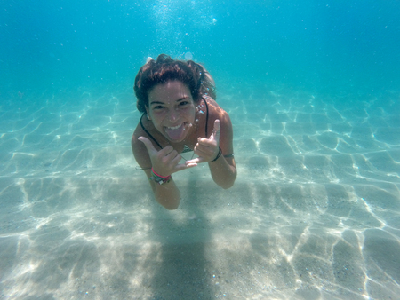 Underwater image of a happy girl divingの写真素材