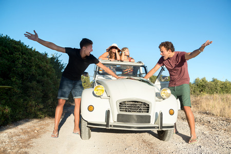 Vintage style image of boys with a map fighting over directions, and girls waiting in the car.