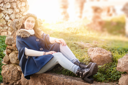 Beautiful happy young girl posing outdoors amongst ruins in beautiful lightの写真素材