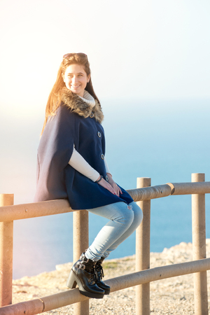 Beautiful happy young girl posing outdoors in a fenceの写真素材