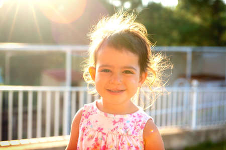 Sweet young girl posing outdoors at sunsetの写真素材