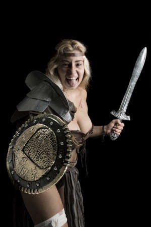 Ancient woman warrior or Gladiator posing in a dark backgroundの写真素材