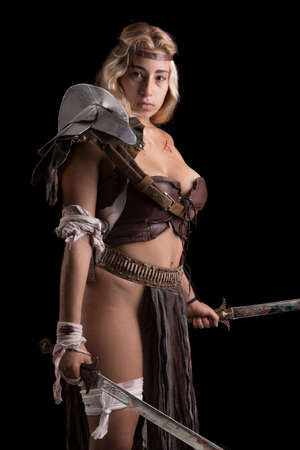 Ancient woman warrior or Gladiator posing in a dark backgroundの写真素材