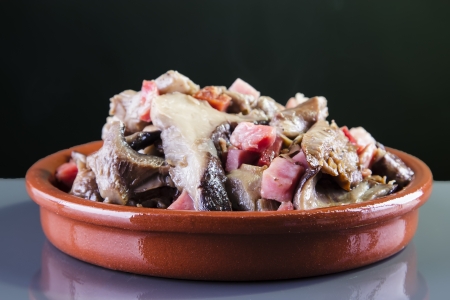 mushrooms with ham on a clay plateの写真素材