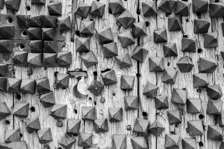 Extreme close-up of wooden door of a castle with four iron nails.の写真素材