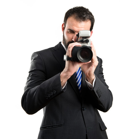 Young businessman recording video over white backgroundの写真素材