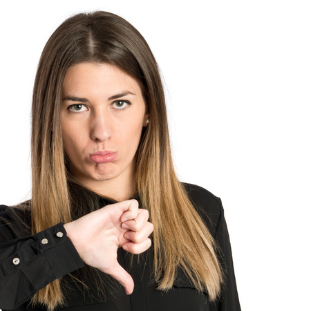Girl with her thumb down over white background 