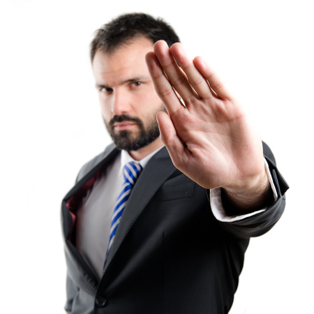 Young businessman doing stop sign over white background の写真素材