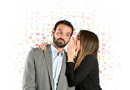young girl whispering to her boyfriend over cute background の写真素材