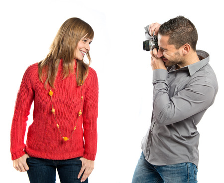 Man photographing a girl over white background の写真素材