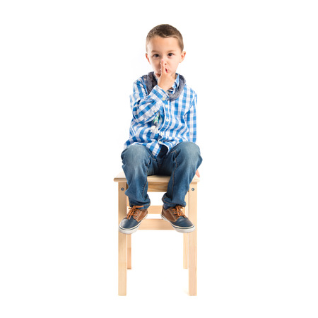 Kid doing silence gesture over white backgroundの写真素材