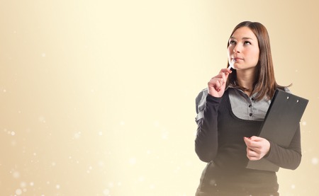 Young student thinking over ocher background の写真素材