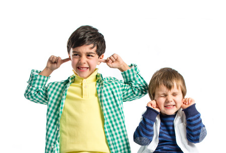 Boys covering his ears over white background. 