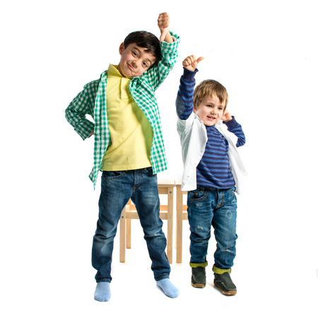 Kids making bad sign over white background の写真素材