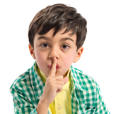 Kid doing silence gesture over white background の写真素材