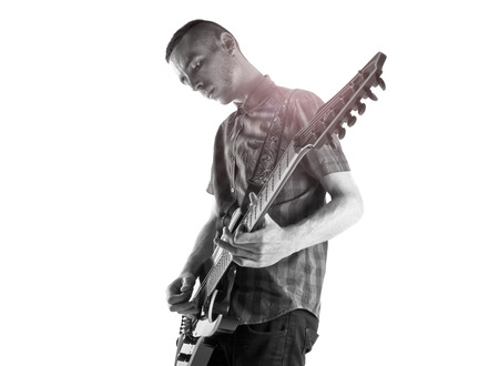 Young man playing guitar over white backgroundの写真素材