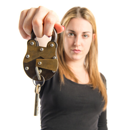 Blonde girl holding vintage padlock over white background の写真素材