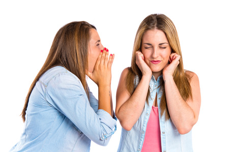 Girl shouting at her friend over white の写真素材