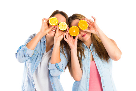 Girl playing with fruits over white の写真素材