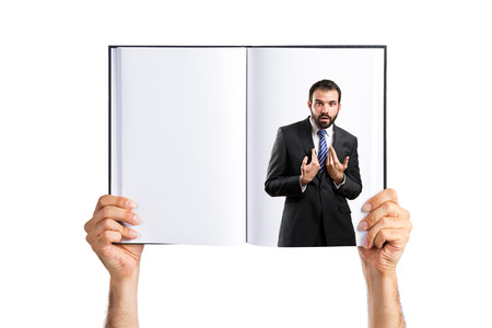 Young businessman surprised printed on bookの写真素材