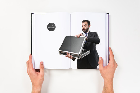 Young businessman open his briefcase printed on bookの写真素材