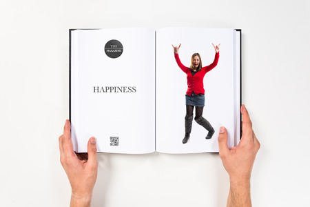 young girl making horn gesture printed on bookの写真素材