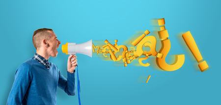 Redhead man shouting by megaphone over blue background.の写真素材