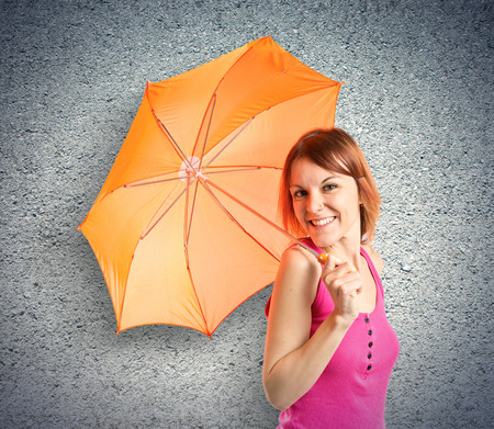Girl holding an umbrella over textured background の写真素材