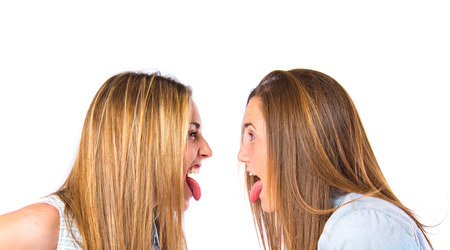 Girls doing a joke over isolated white backgroundの写真素材