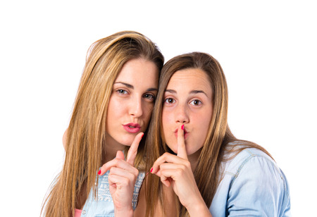 Friends making silence gesture over isolated white backgroundの写真素材