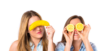 Friends playing with fruits over white backgroundの写真素材