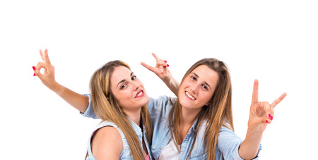 Friends making horn gesture over white backgroundの写真素材