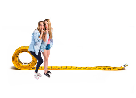 Friends making silence gesture over isolated white backgroundの写真素材