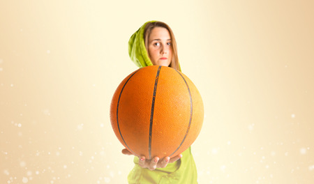 Blonde girl playing basketball over gloss backgroundの写真素材
