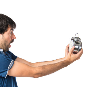 Man holding a clock over white backgroundの写真素材