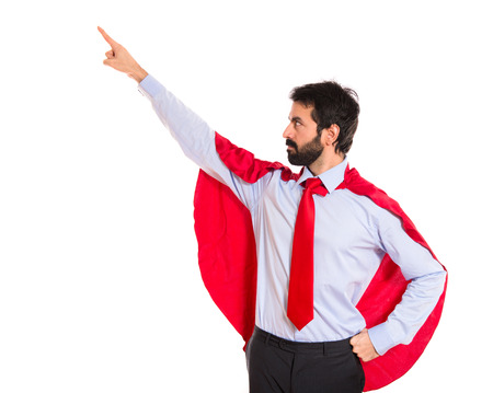 Businessman dressed like superhero pointing to the lateralの写真素材