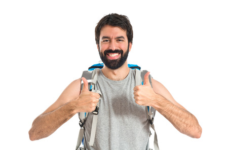 Backpacker with thumb up over white backgroundの写真素材