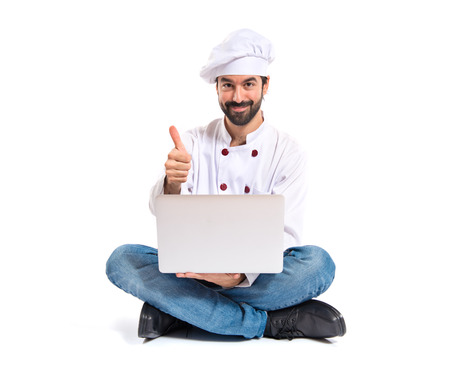 Chef with laptop over isolated white backgroundの写真素材