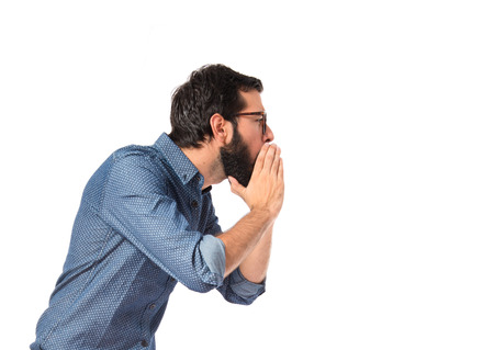 Young hipster man shouting over white background