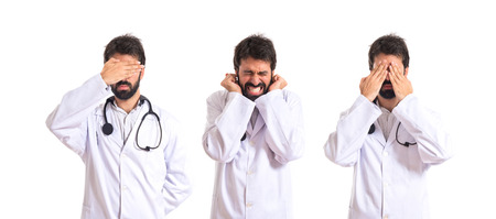 Doctor covering his ears over white backgroundの写真素材