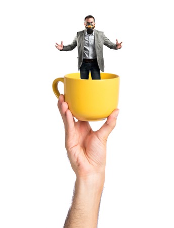 young businessman with gas mask inside cup of coffeeの写真素材