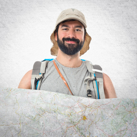 Backpacker with map over white backgroundの写真素材