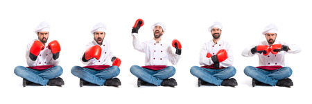 Chef with boxing gloves sitting on the floorの写真素材