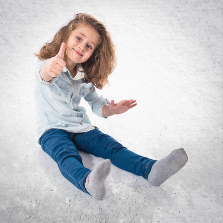 Blonde little girl with thumb upの写真素材