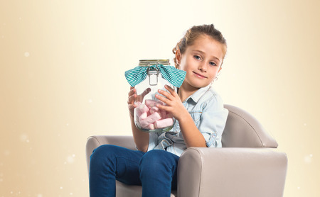 Blonde girl holding jar glass with sweetmeats insideの写真素材