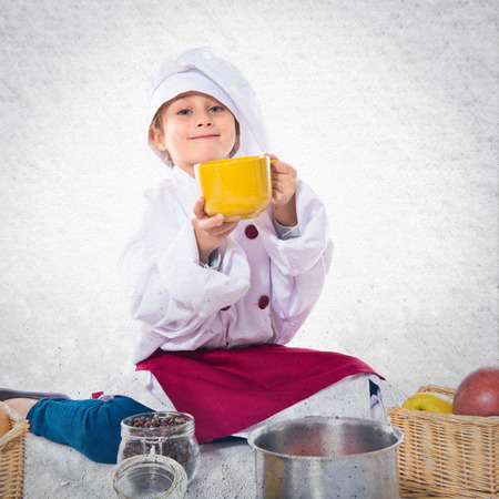 Girl dressed like chef  holding a cup of coffeeの写真素材
