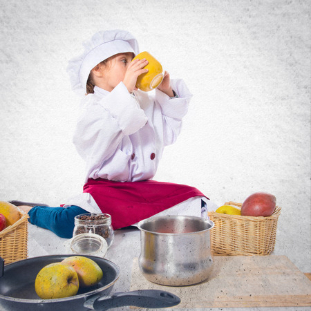 Girl dressed like chef  holding a cup of coffeeの写真素材