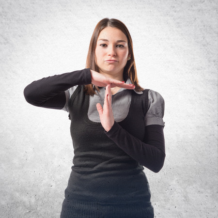 Young girl making time out gesture over white backgroundの写真素材