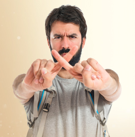 Backpacker doing NO gesture over white backgroundの写真素材